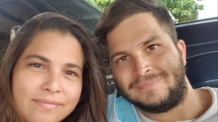 A man with a beard and a woman with long brown hair smile at the camera 