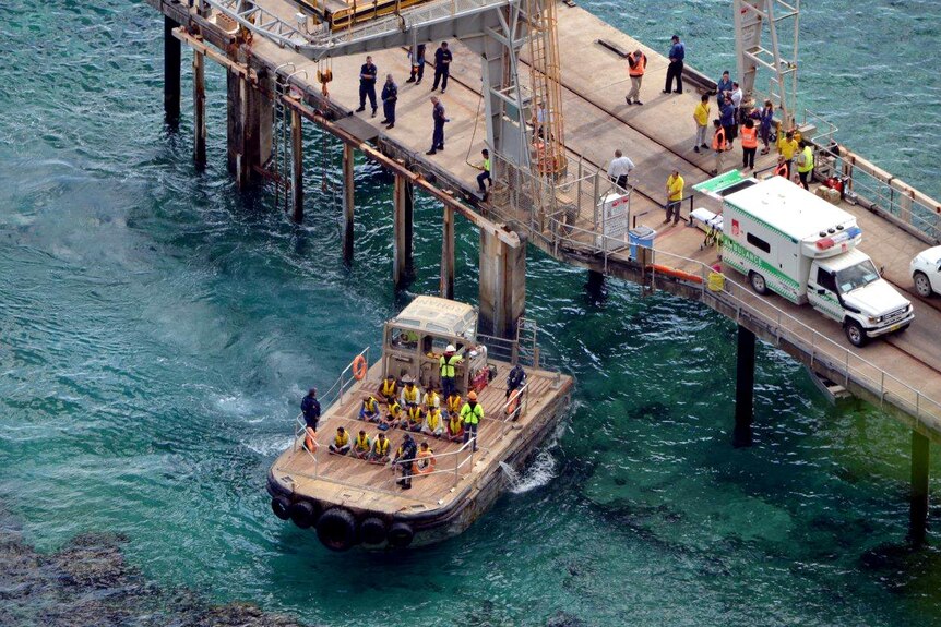 A barge transports asylum seekers to the dock at Christmas Island.