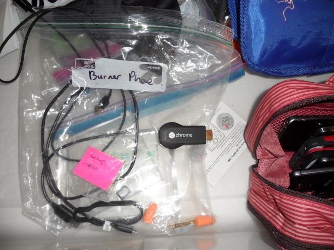 A ziplock bag containing cords for electronic devices is labelled "burner phone" in black marker