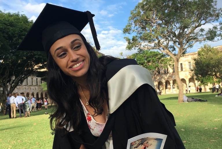 A woman wearing a university graduation cap and cape.