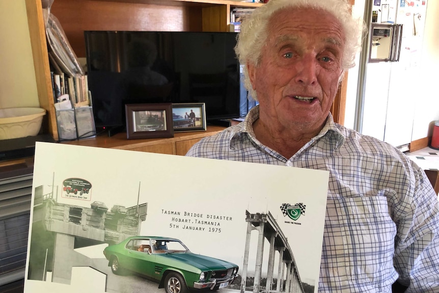 Frank Manley, Tasman Bridge disaster survivor, holds a poster commemorating the famous photo of his Holden Monaro