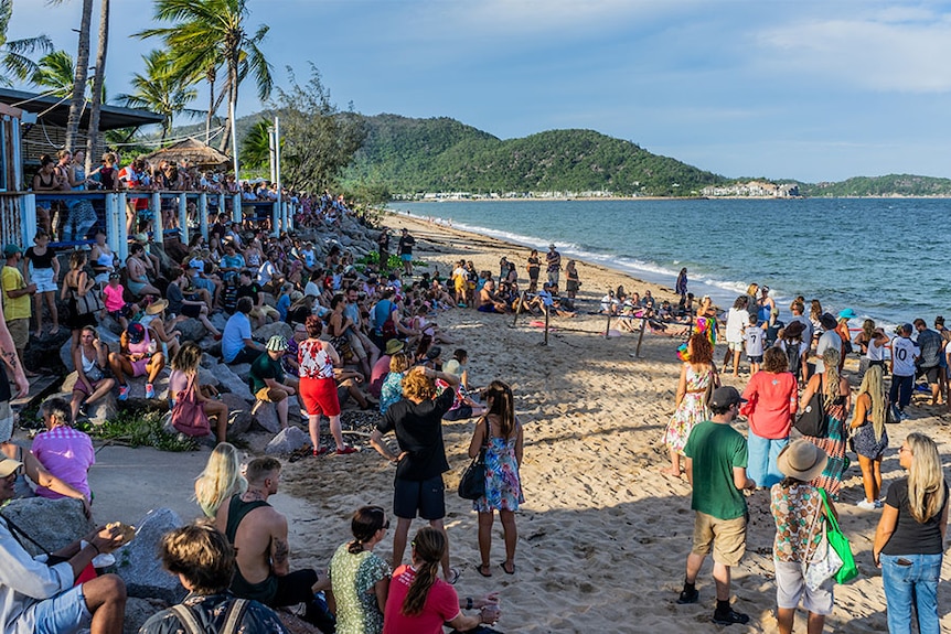 A large crowd of people gathered on a beach.