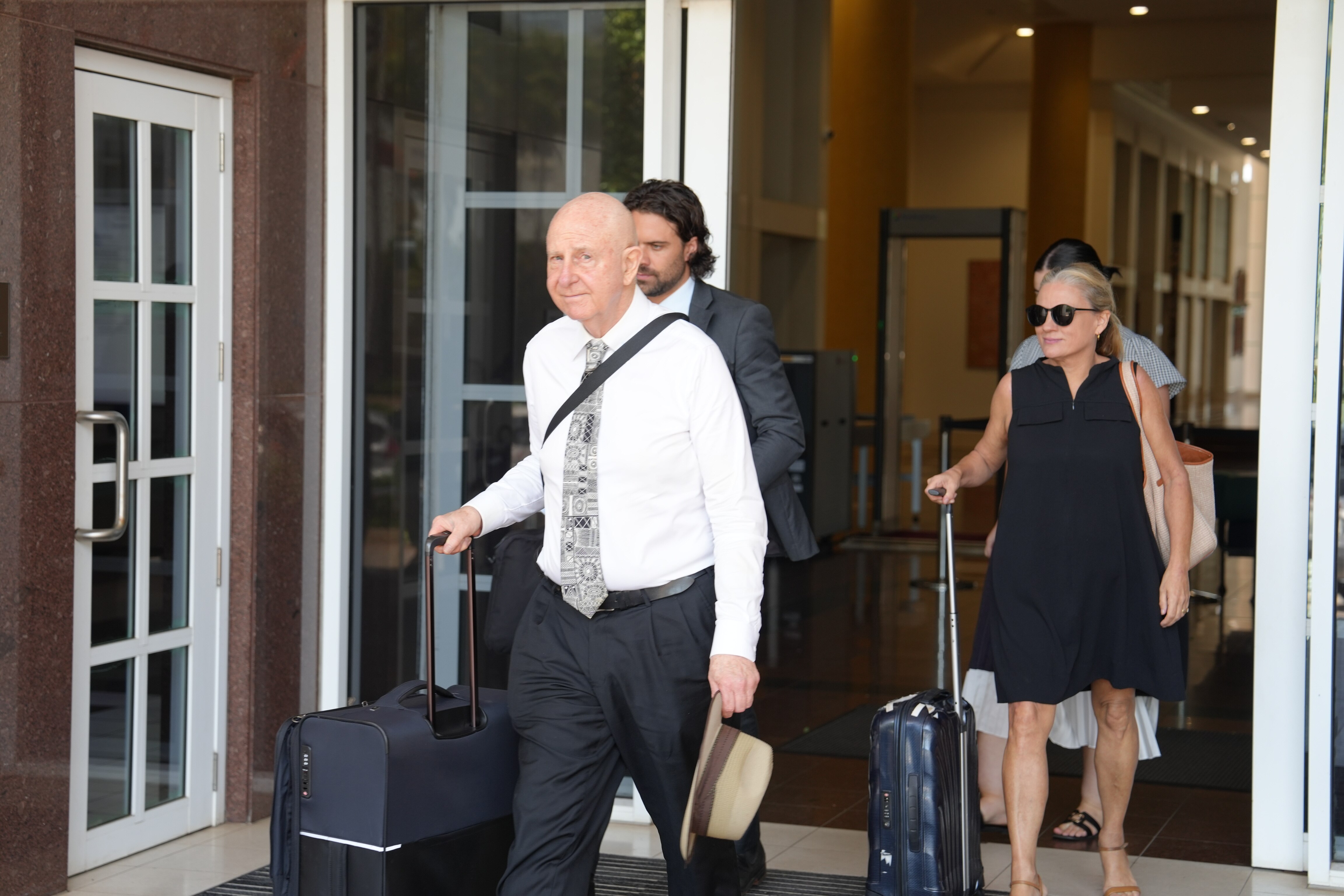 Un hombre calvo con camisa y corbata sale del juzgado.