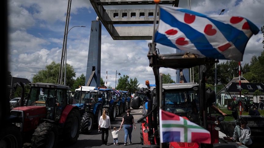 The flag of the Frysian province flies from a tractor as protesting farmers block a draw bridge.