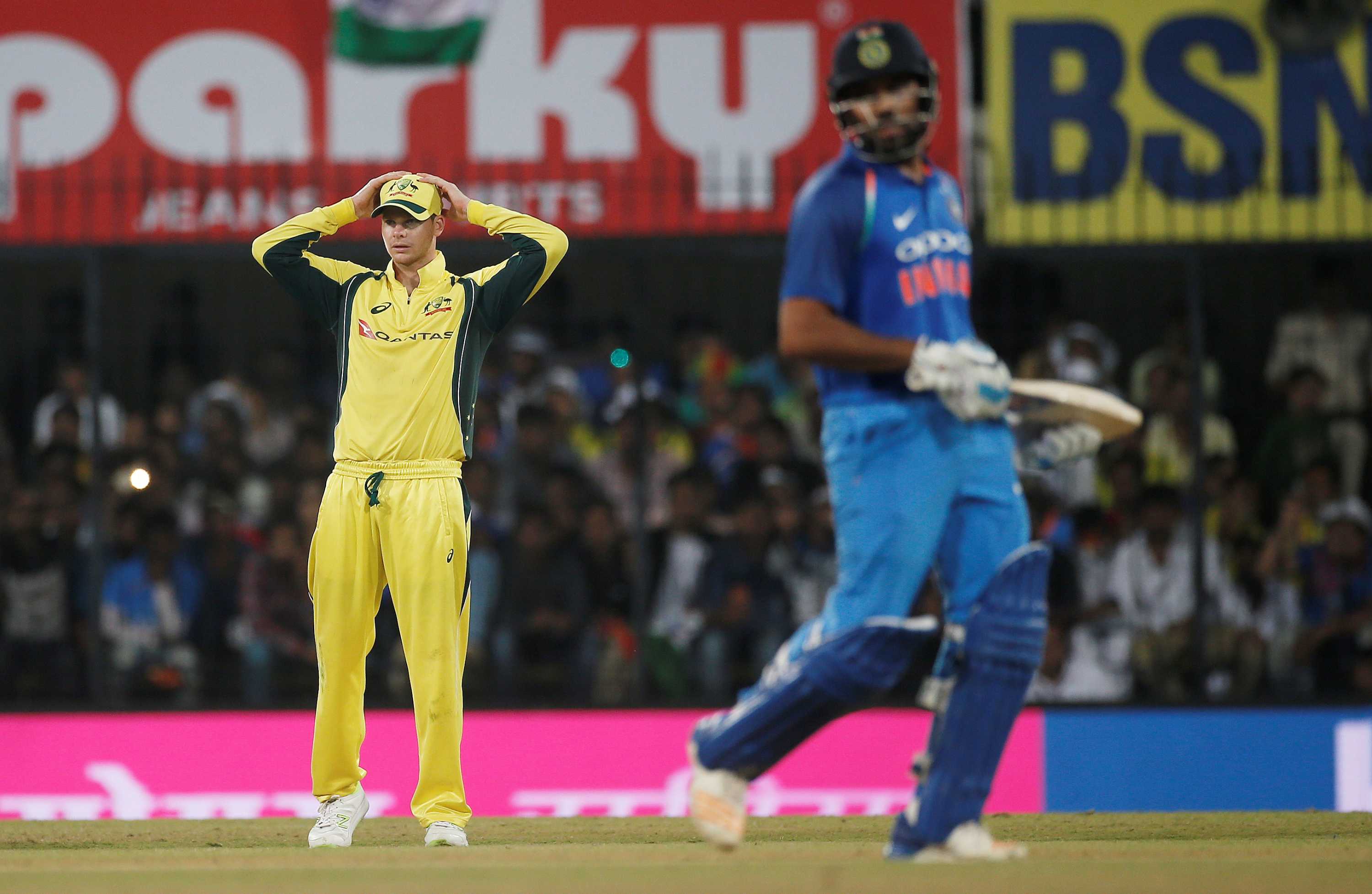 Australia's captain Steven Smith stands in the field with hands on head.
