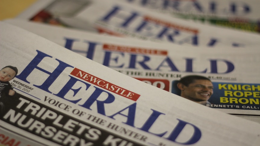 A stack of copies of the Newcastle Herald newspaper.