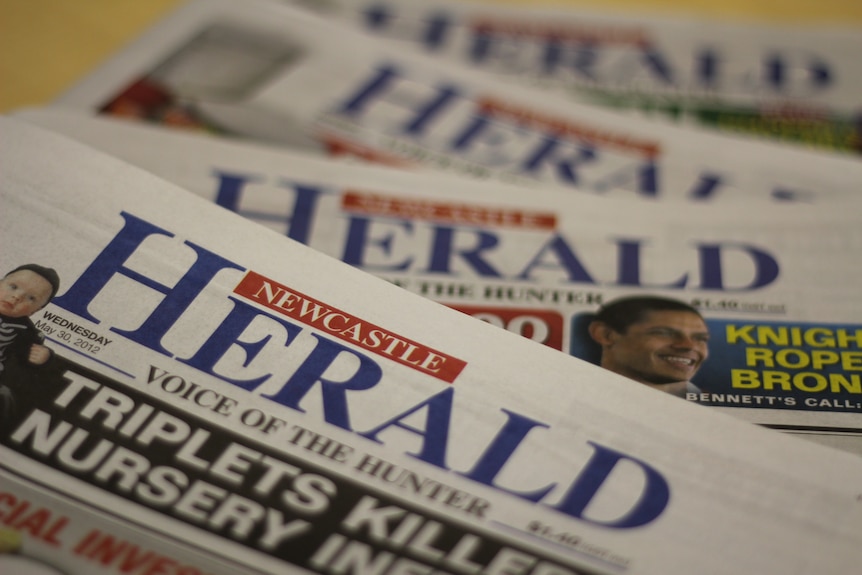 A stack of copies of the Newcastle Herald newspaper.