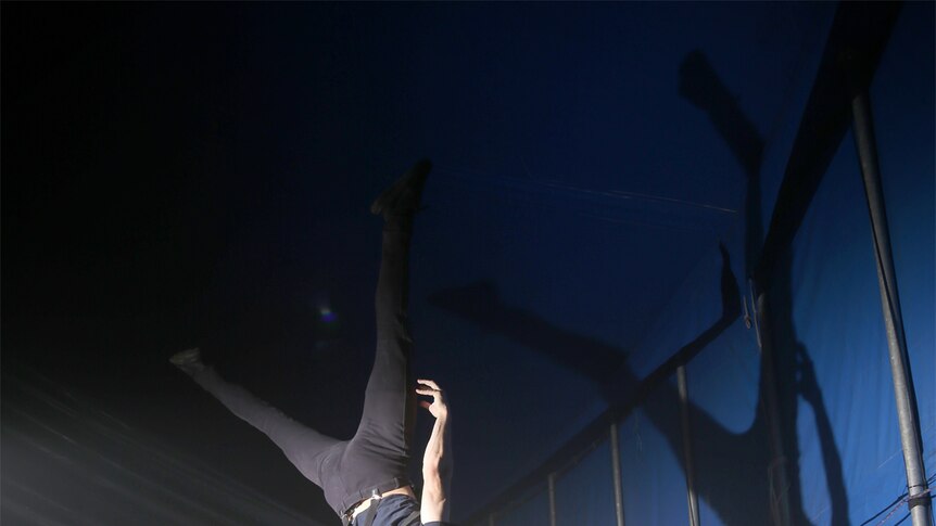 Jordan Ashton practices balancing backstage at Infamous.
