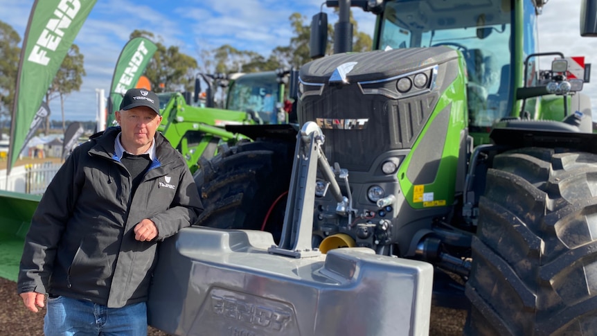 Tasmac managing director Tony Brooks leans casually on one of his borrowed tractors.