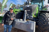 Tasmac managing director Tony Brooks leans casually on one of his borrowed tractors.