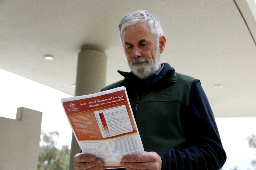 Don Fletcher reads a pamphlet titled "Geothermal energy: Opportunities for Australia".