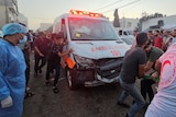 Palestinians pull a damaged ambulance after it was hit in a strike.  