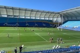 team training on a rugby league field at Robina with empty seats 