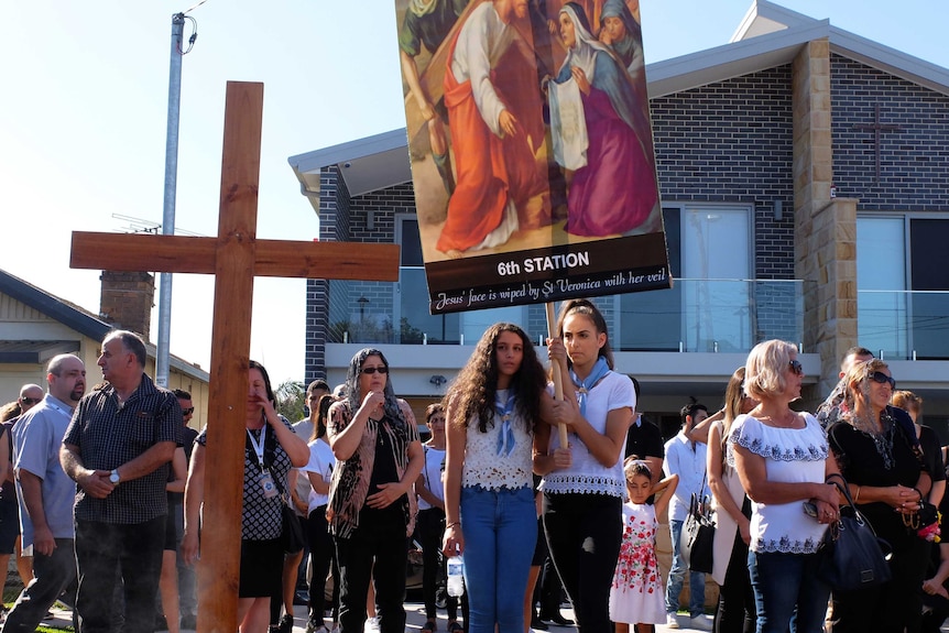 Two members of St Charbel's youth group mark the sixth station of the Cross for the Good Friday procession.