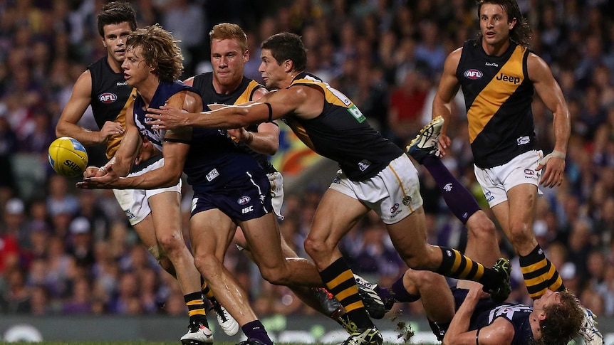 Fremantle's Nathan Fyfe handballs under pressure against Richmond at Subiaco.