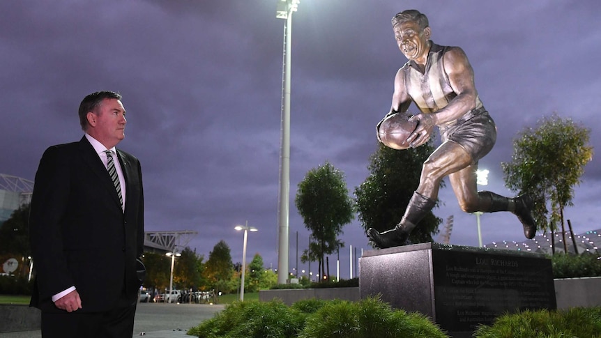 Eddie McGuire looks at a statue of Lou Richards.