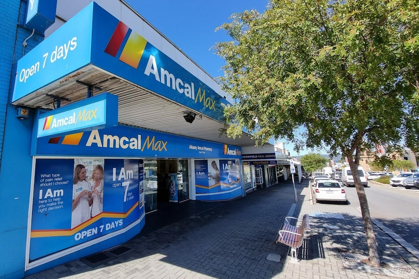Exterior Amcal Pharmacy from the street with tree out the front.