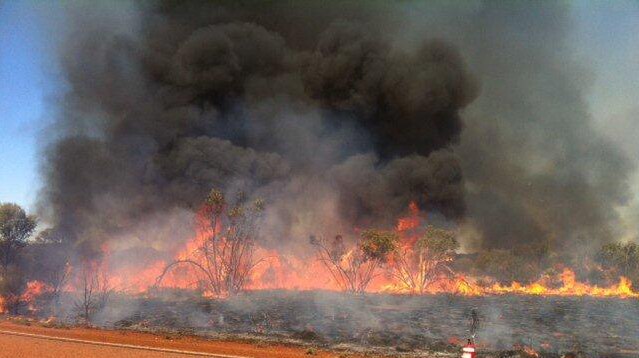 Black smoke billows from a bushfire in scrub near Laverton in WA