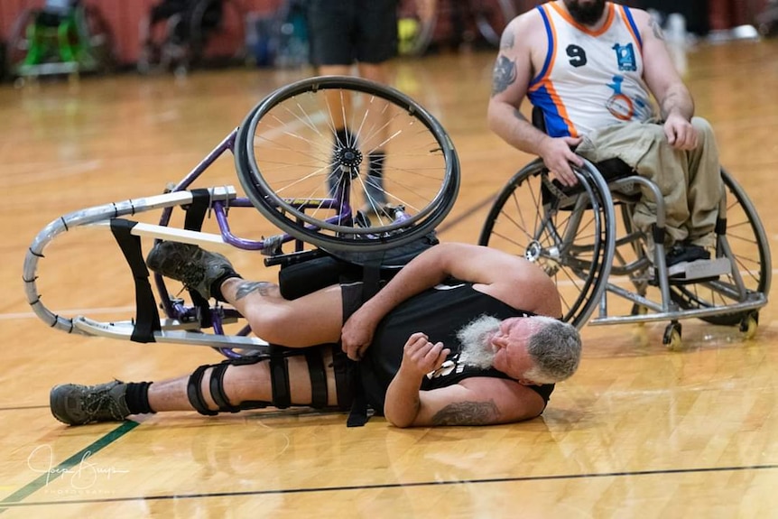 Robert Piper's chair tips up in a game of wheelchair basketball.