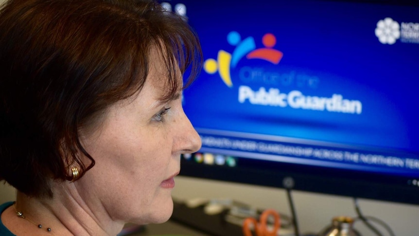 A photo shows NT Public Guardian Beth Walker looking at her computer.