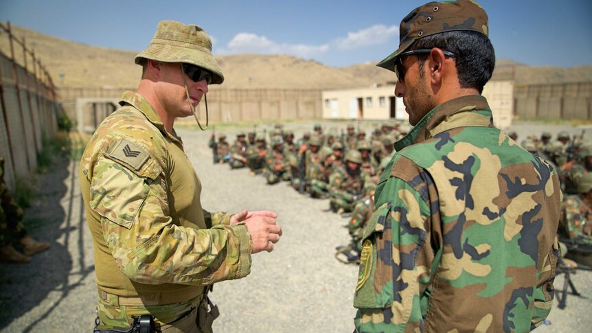 Digger in uniform speaks to Afghan officer