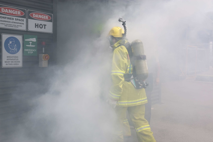 ABC News Canberra journalist Alkira Reinfrank enters a room filled with smoke.