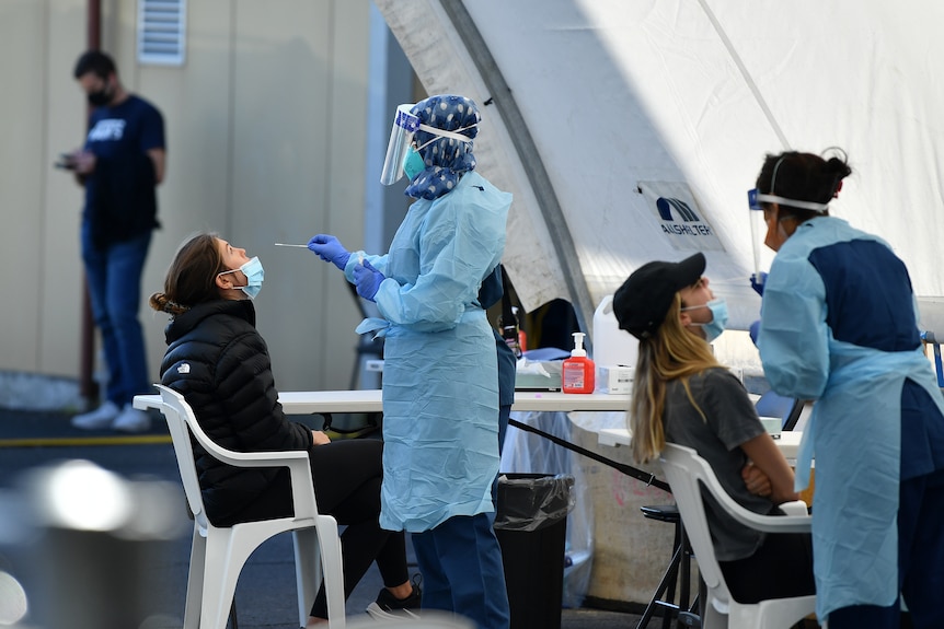 people in a tent getting their nose swabbed