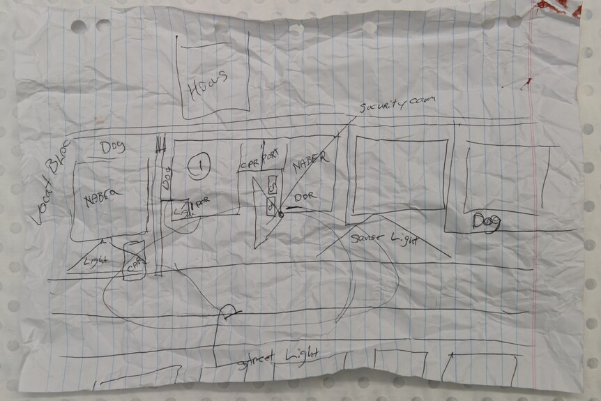 A map sketched in pen on ruled notebook paper including mentions of a security camera, sensor light, dog and street light