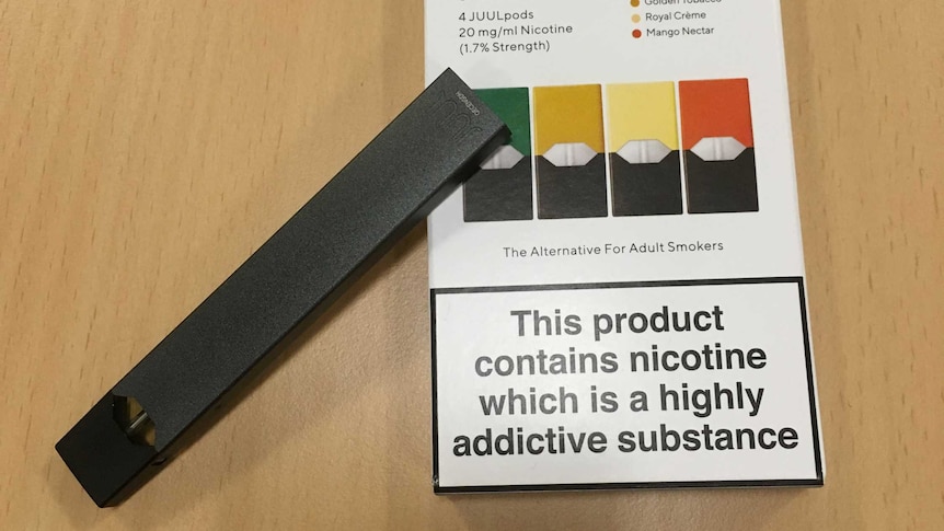 An e-cigarette perched on a packet called Juul starter pack.