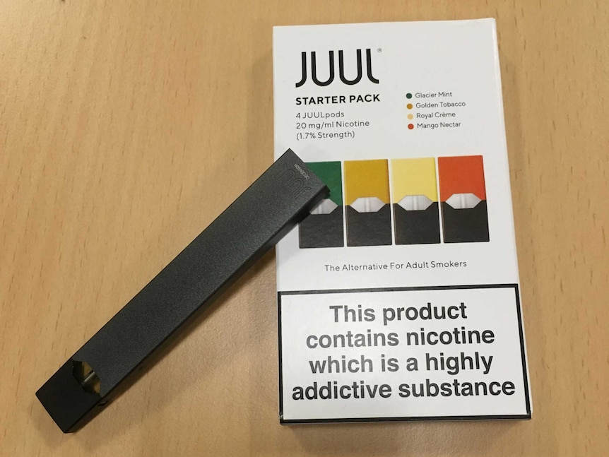 An e-cigarette perched on a packet called Juul starter pack.