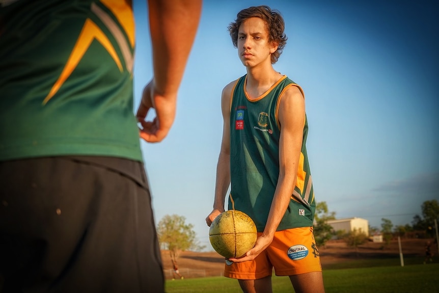 Jacob Long handballs the AFL ball during training