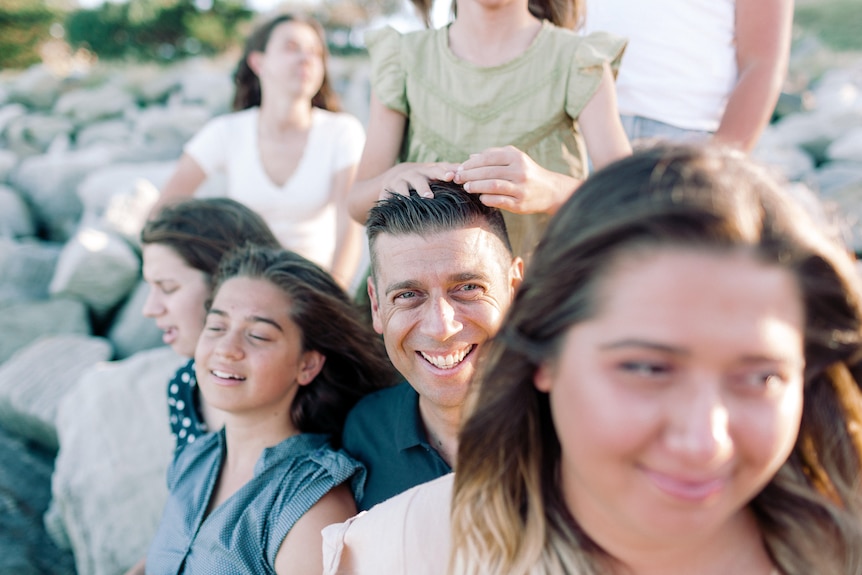 Parenting expert Justin Coulson surrounded by his 6 daughters