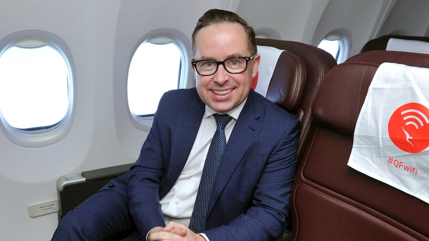 Alan Joyce sits inside a plan on a chair