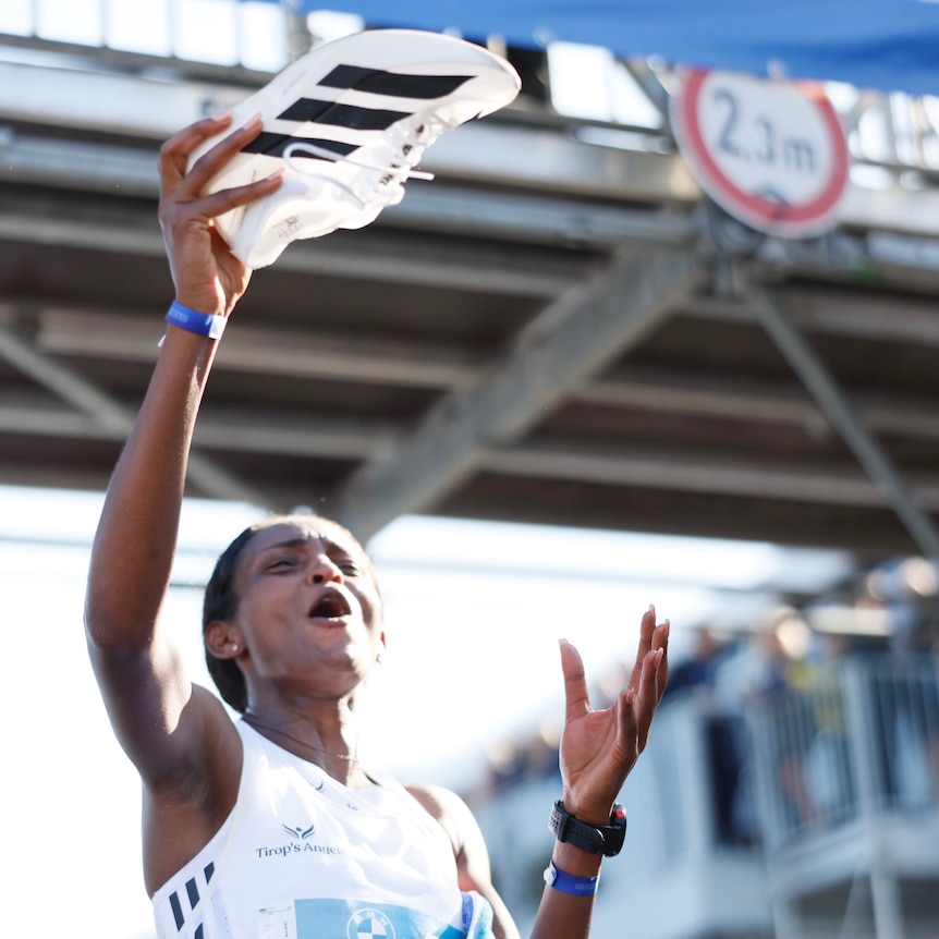 Tigist Assefa holds up the Adidas Adizerio Adios Pro Evo 1 running shoe