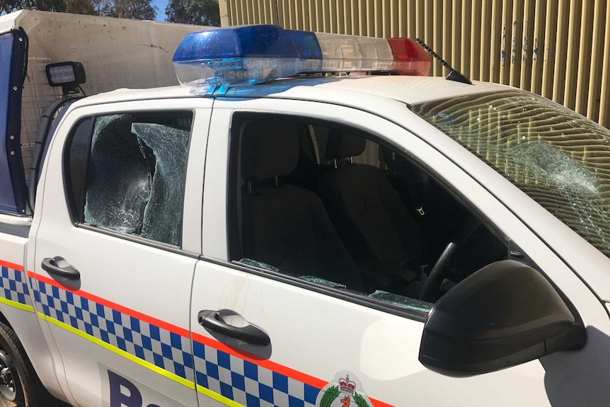 A police car in Alice Springs was left damaged after officers attending a town camp were attacked by a large mob.