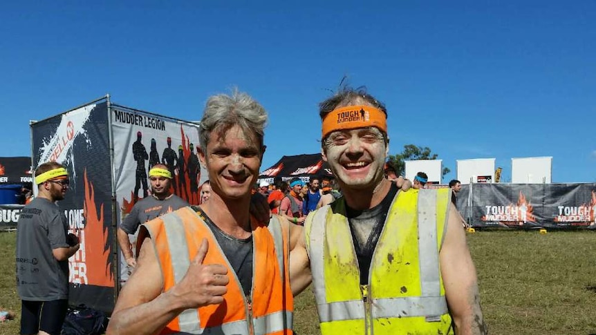 Coach Norbert Petras (left) and blind runner Robin Braidwood smiling after 18 kilometre obstacle course