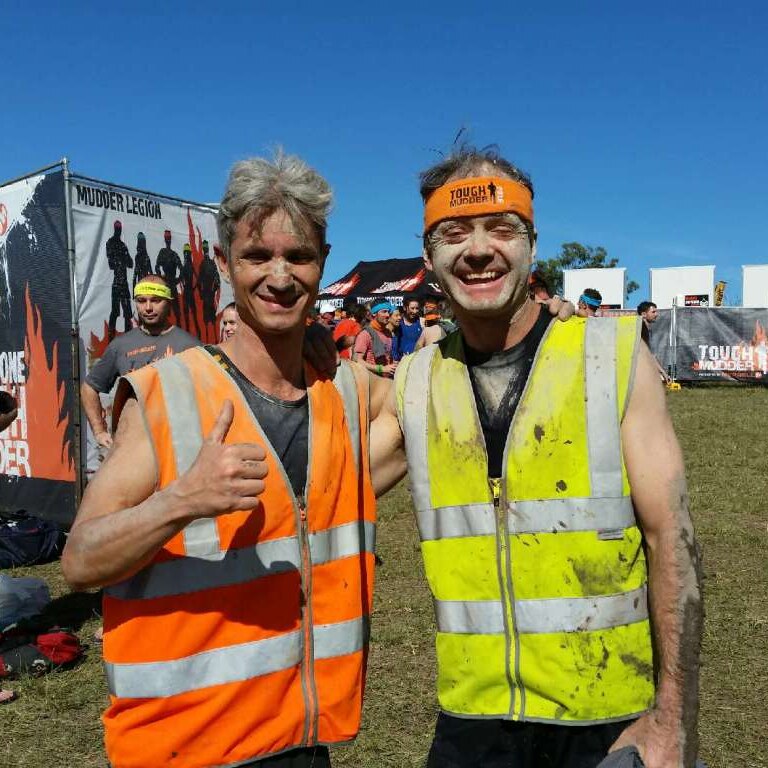 Coach Norbert Petras (left) and blind runner Robin Braidwood smiling after 18 kilometre obstacle course