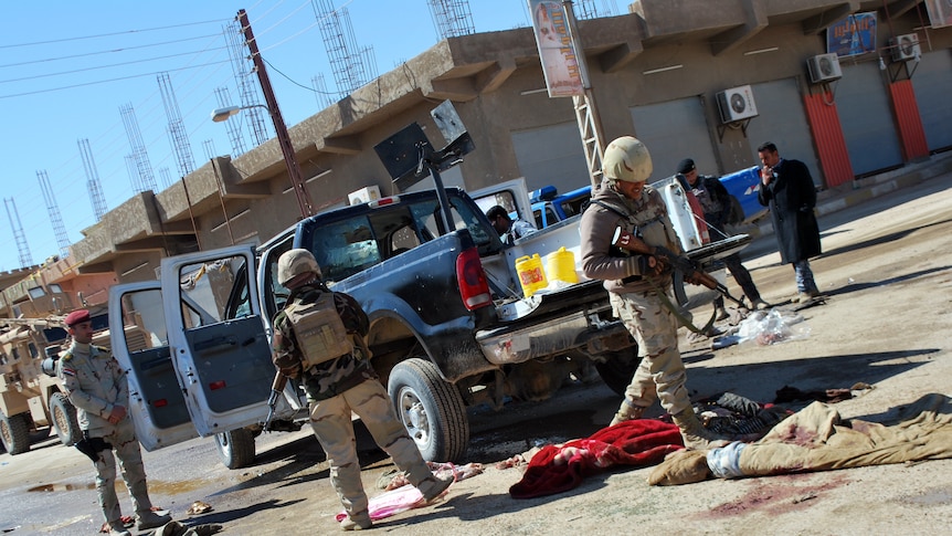 Iraqi police inspect the scene after policemen were slain in the western city of Haditha on March 5, 2012.