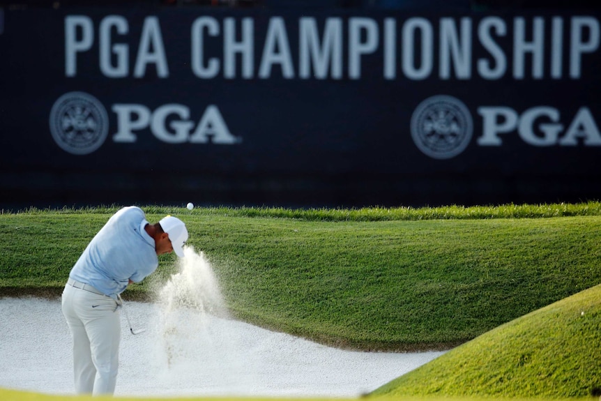 Brooks Koepka hits out of a bunker.