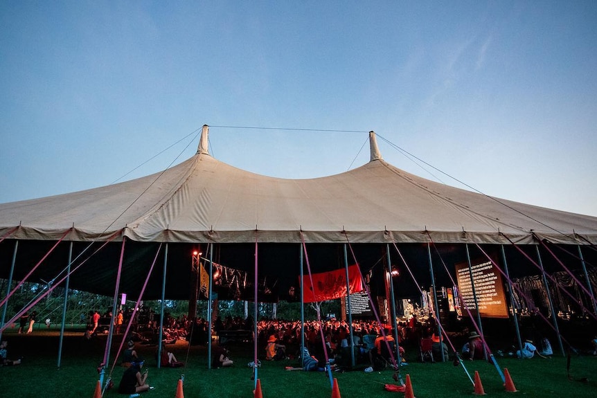 A large white tent with people under it