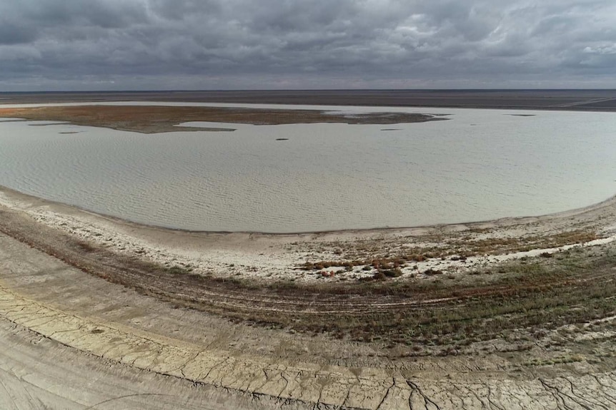 A wide aerial shot shows a large body of water with patches of dry land