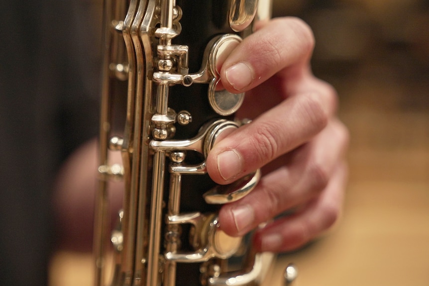 Hands holding a clarinet.