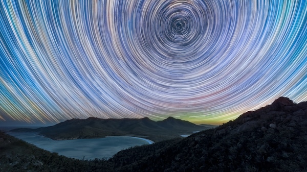 Star trails over land and water