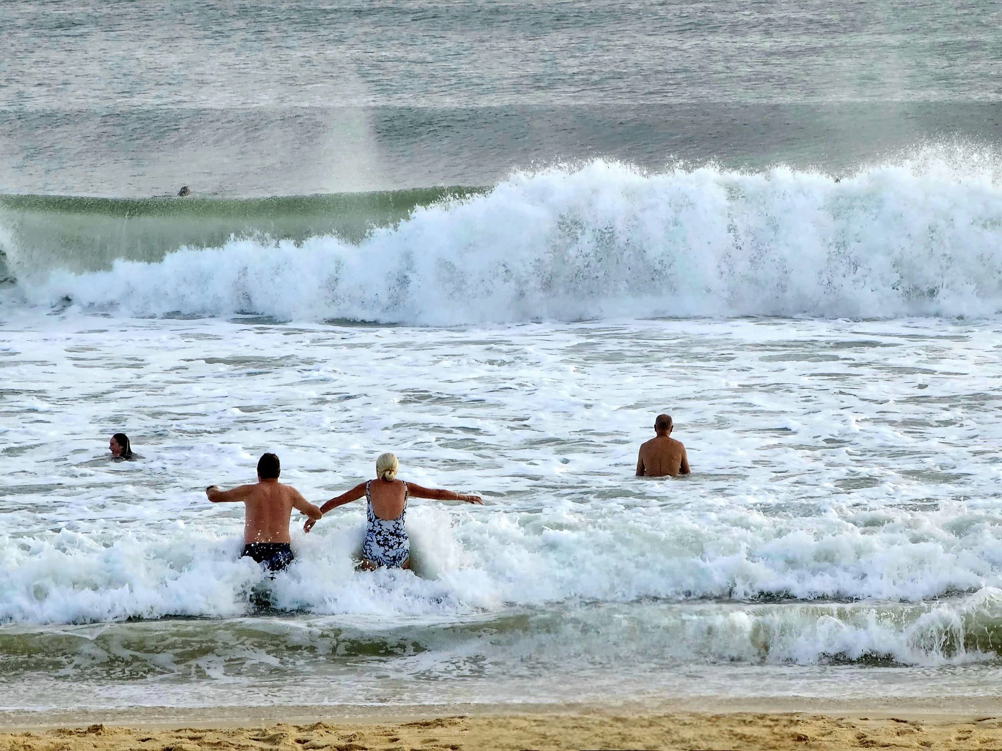  People dive into the water at Mooloolaba Beach.