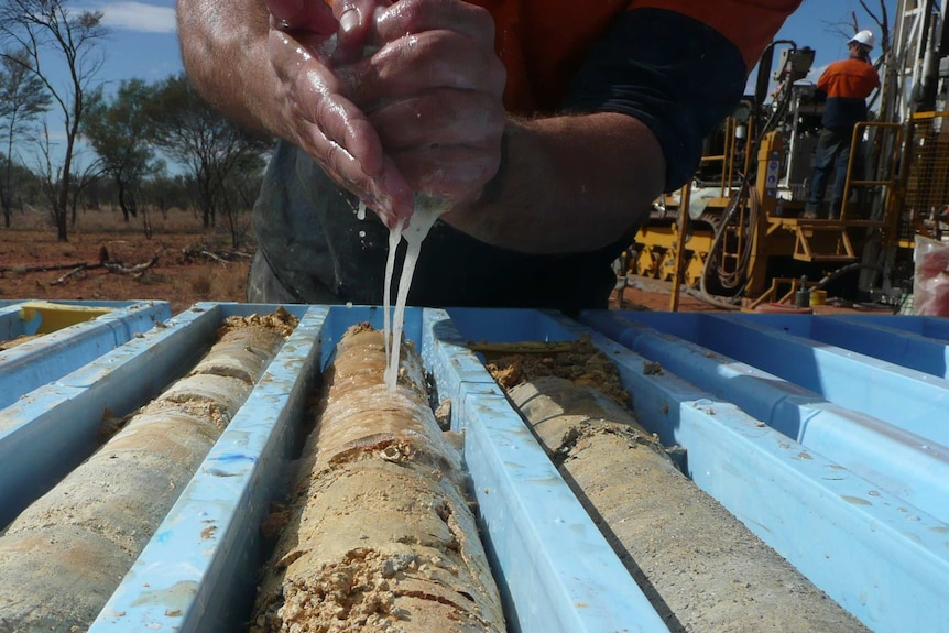 A worker drains liquid into phosphate.