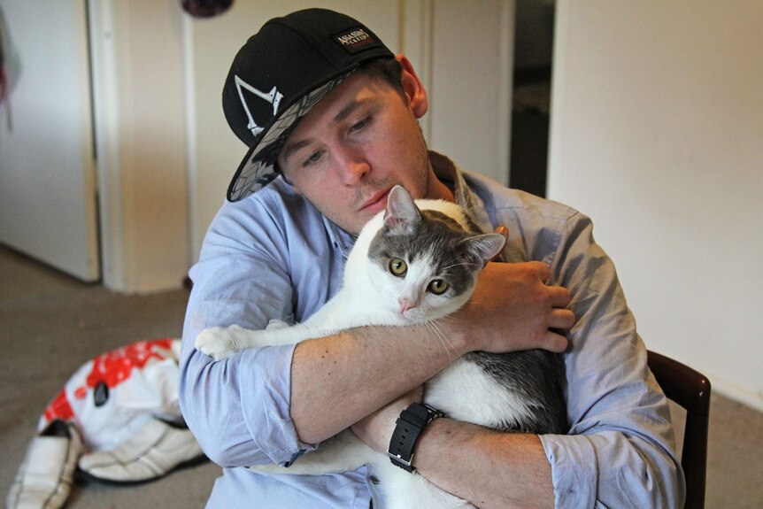 Corey with a cat on his lap.