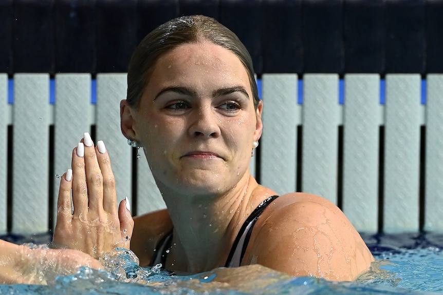 Shayna Jack smiles and holds her hand up