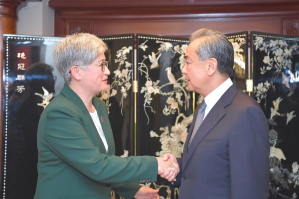 Penny Wong and Wang Yi shake hands.