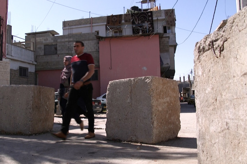 A roadway is barricaded off at the entrance to Aroub camp.