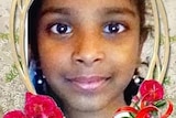 A head shot of a smiling young girl in a frame with red flowers around it.